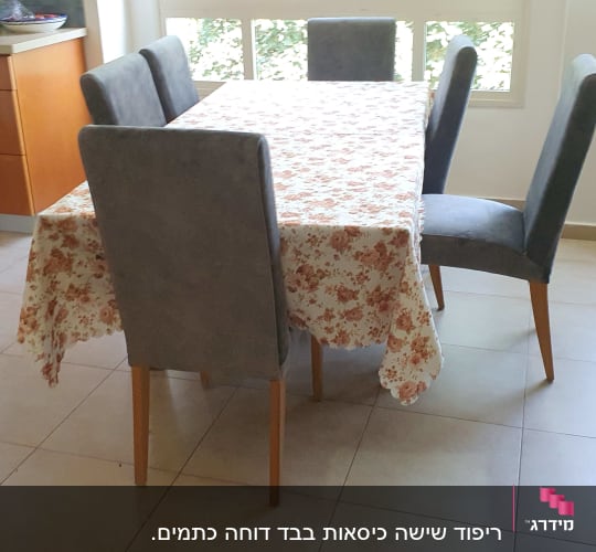 שולחן עם מפה פרחונית וכיסאות מרופדים
